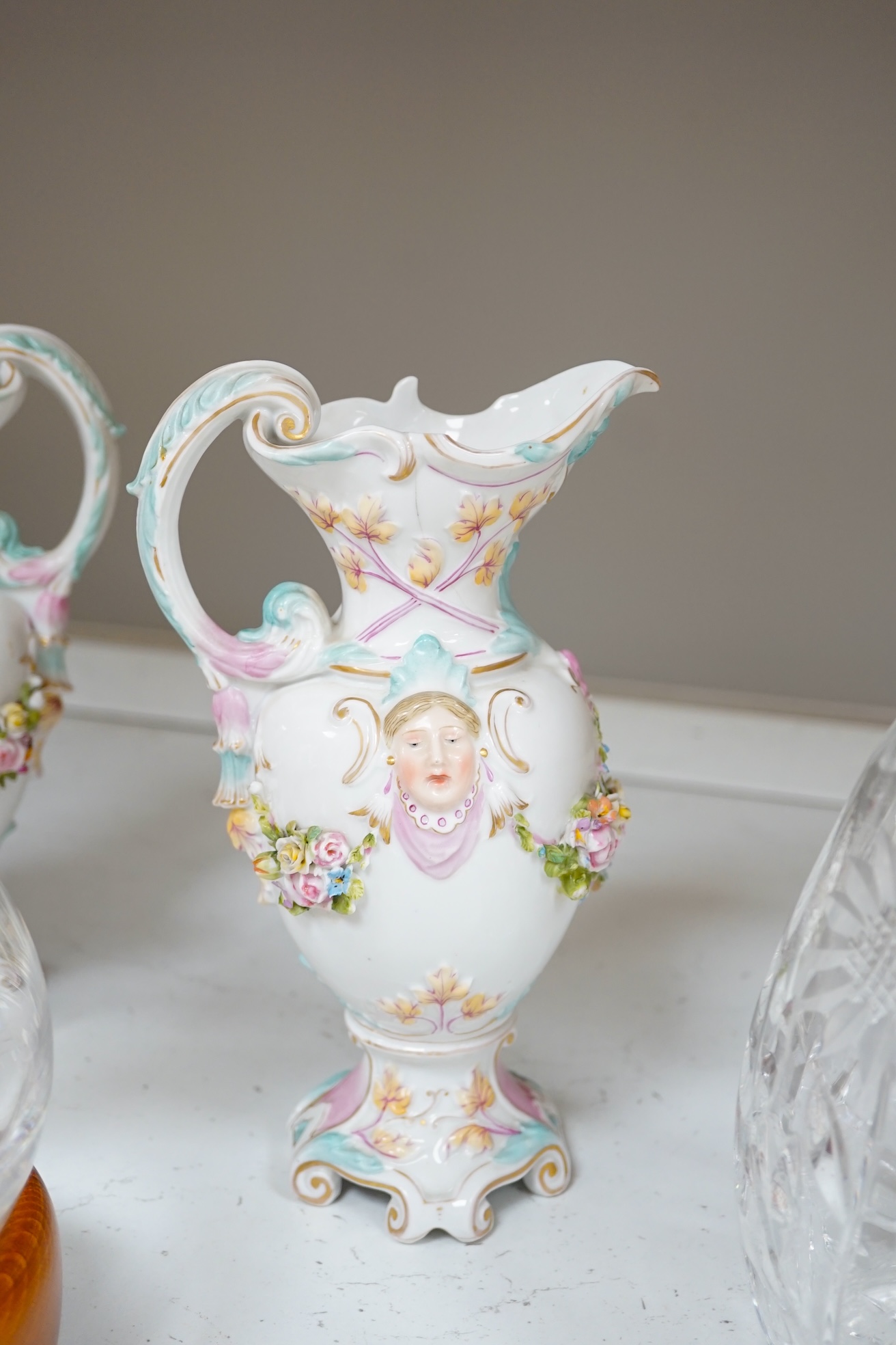 A collection of glassware and ceramics comprising Waterford decanter, two other decanters, German porcelain, ewers and a figure group, largest 40cm high. Condition - varies